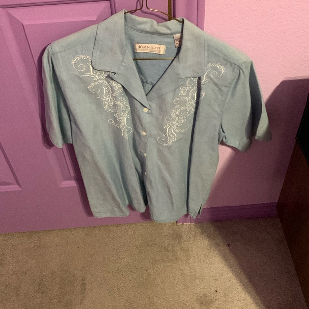 Light blue button-down top with white design on front